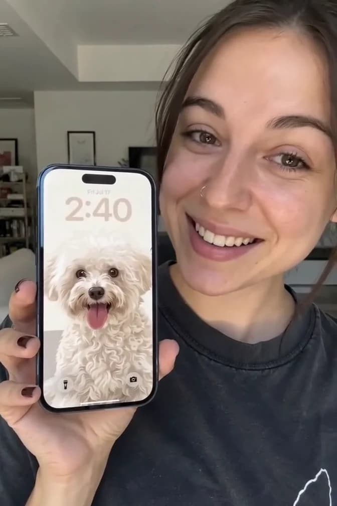 A customer holding a phone with her finished dog Pawtrait wallpaper